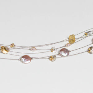 Zarte Halskette mit Perlen und silbernen und vergoldeten Plättchen.
