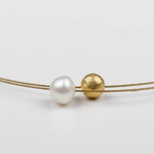 Perle und Goldkugel auf einem doppelten Halsreif.