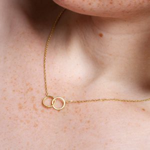 Minimalistische Halskette in Gold. Zwei goldene Ringe sind miteinander verbunden und hängen an einer feinen Goldkette. Material Silber vergoldet.